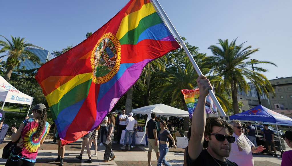 A protester waving a pride flag with the Florida State Seal joined hundreds of people from across the state in a rally and march, Monday, May 1, 2023, in Orlando, Fla. (AP)
